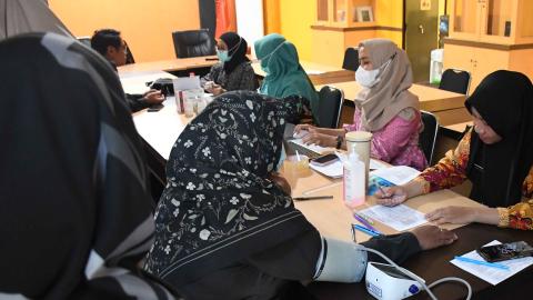 staf Bawaslu sedang dicek kesehatannya oleh tenaga kesehatan 