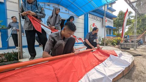 Pemasangan bendera oleh staf Bawaslu